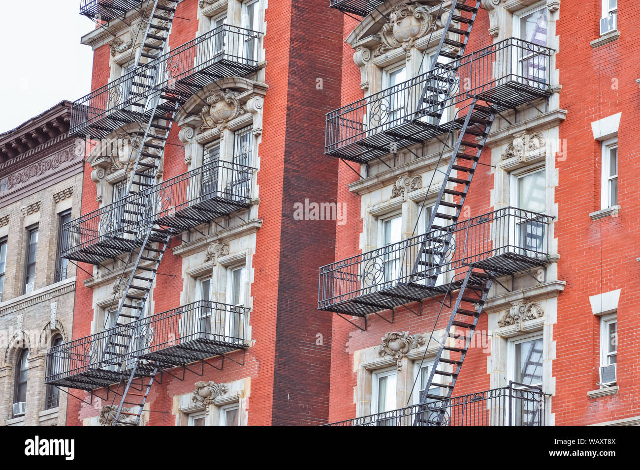 Facciata in mattoni rossi e le scale antincendio. Harlem, NYC. Foto Stock