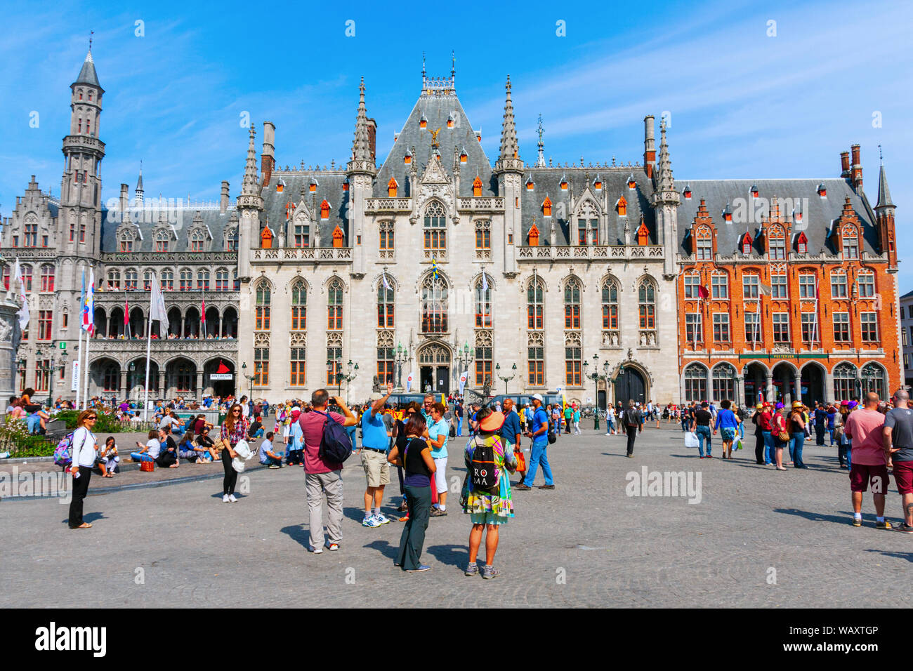 La Piazza del Mercato con il neo-gotica Provincia Corte edificio, affollato di turisti visite in un assolato pomeriggio in estate. Bruges, Belgio. Foto Stock