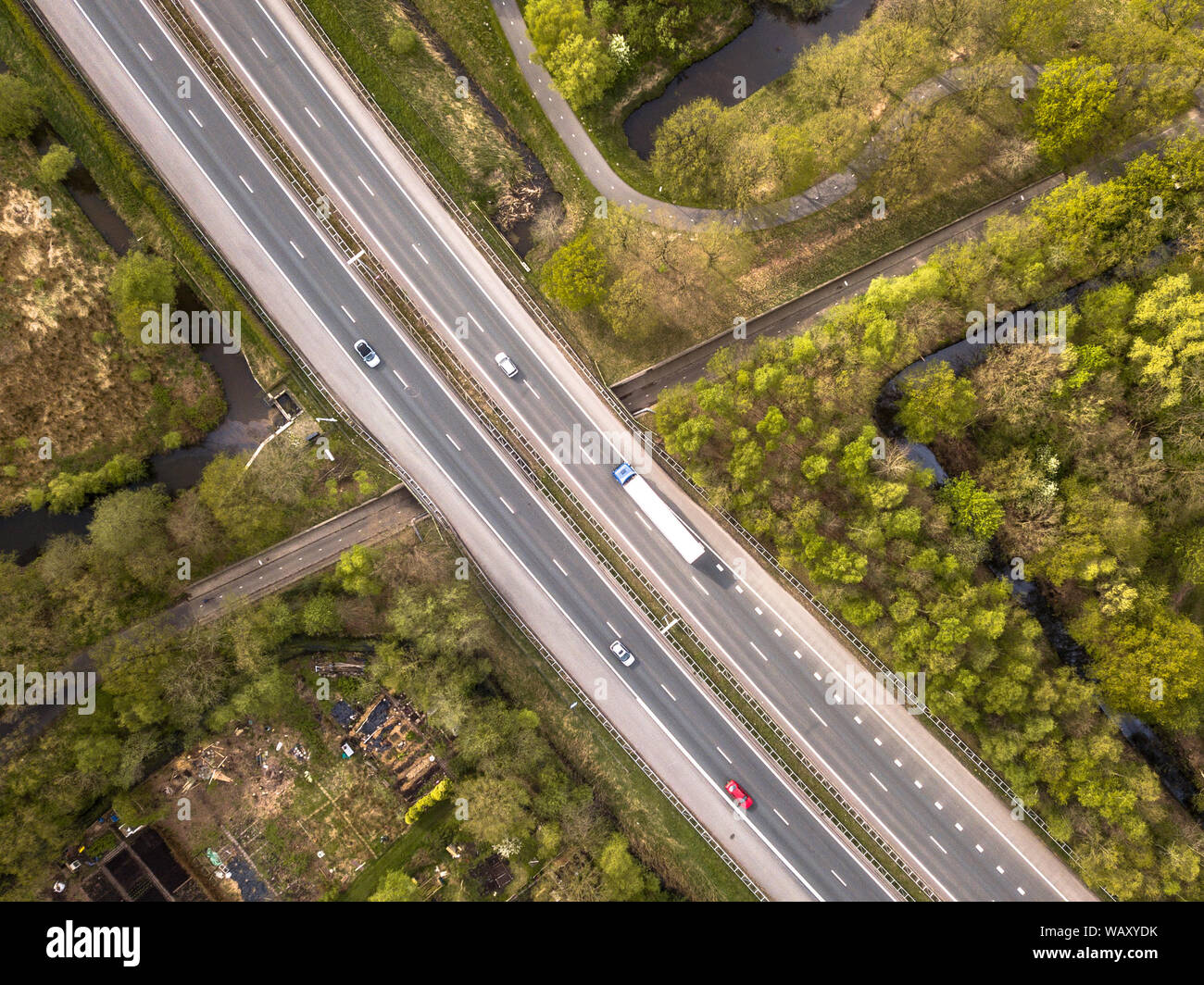 Vista aerea di quattro lane motorway con corsia di emergenza e traffico moderato durante le ore di punta Foto Stock