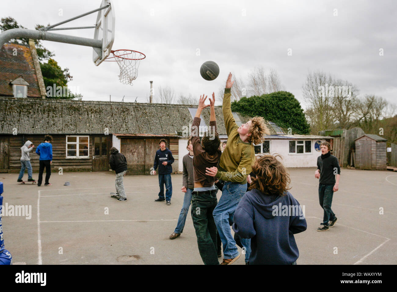 Gli alunni giocare a basket nel parco giochi presso il Waldorf Steiner School in Hereford, Regno Unito Foto Stock