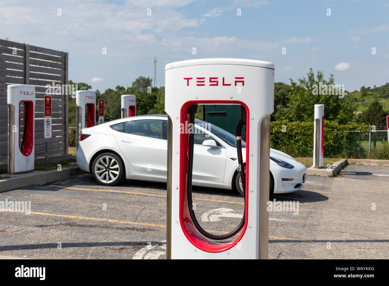Tesla Supercharger stallo in-anteriore inserito in bianco modello Tesla 3. Foto Stock