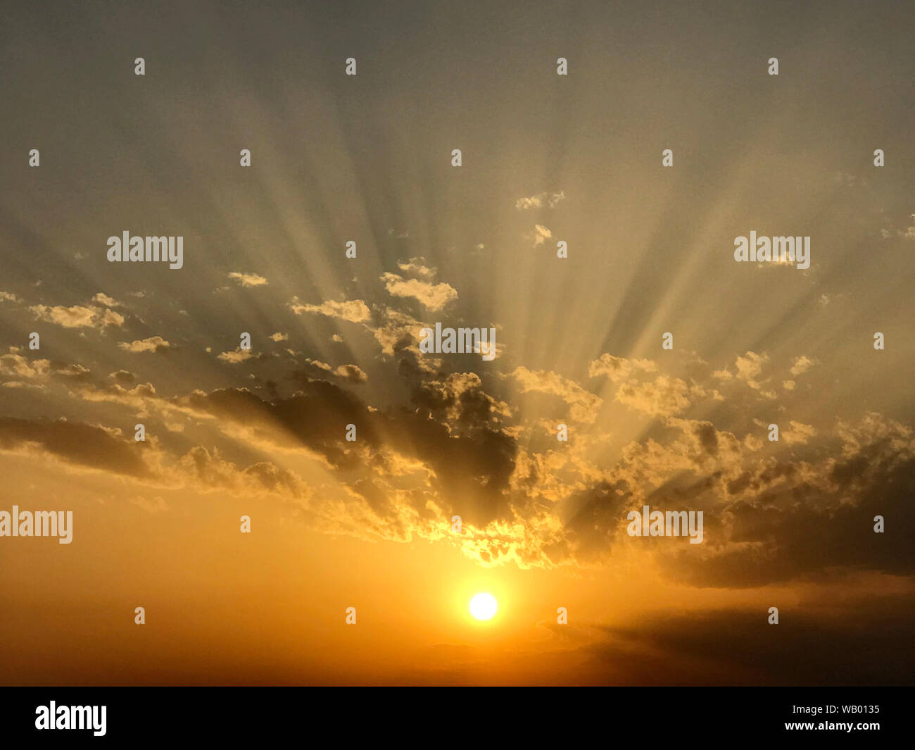 Tramonto con le nuvole e raggi Foto Stock