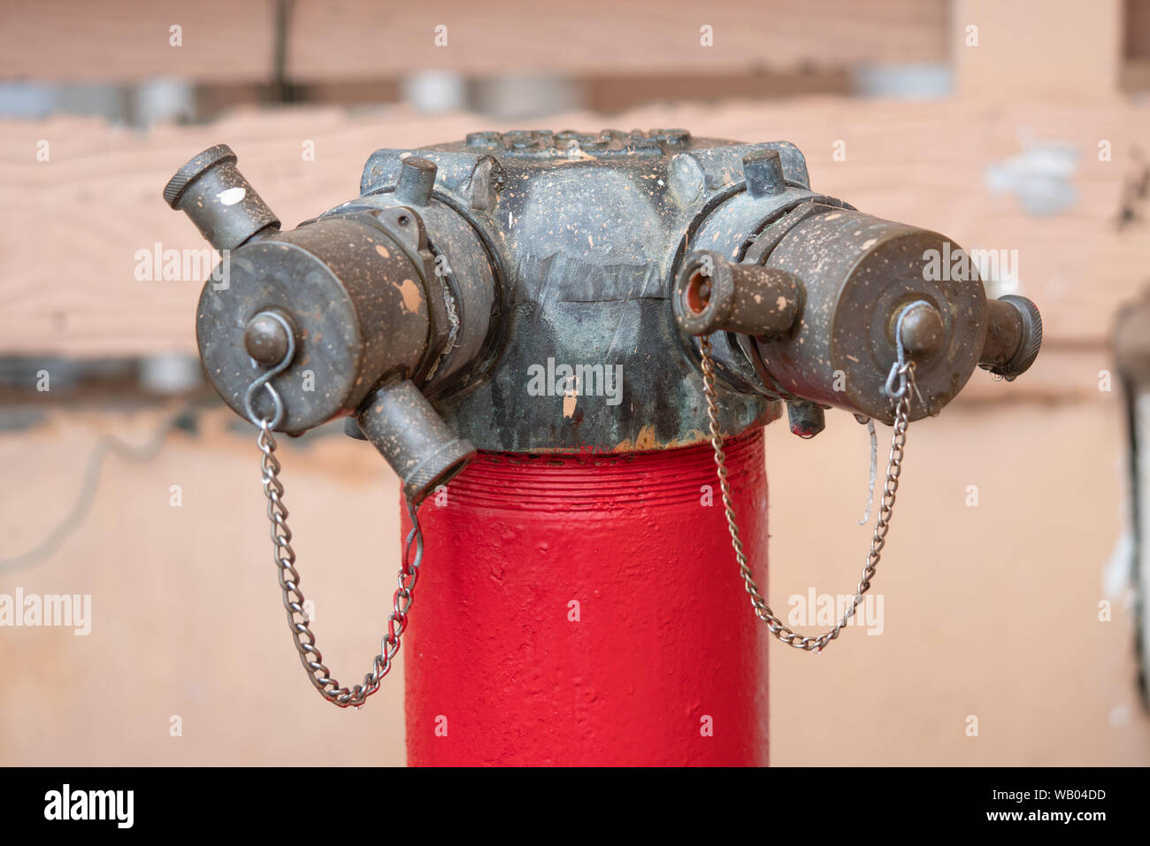Rosso fuoco idrante a tubo di acqua con una catena sulla strada Foto Stock