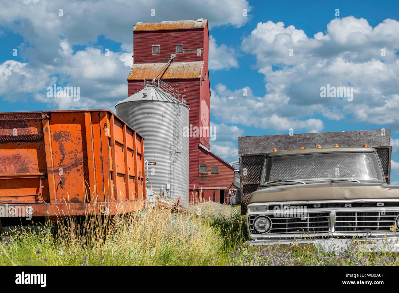 Cadillac, SK/Canada- Luglio 29, 2019: la storica Cadillac di elevatore della granella in Saskatchewan, Canada con due vecchi camion in primo piano Foto Stock