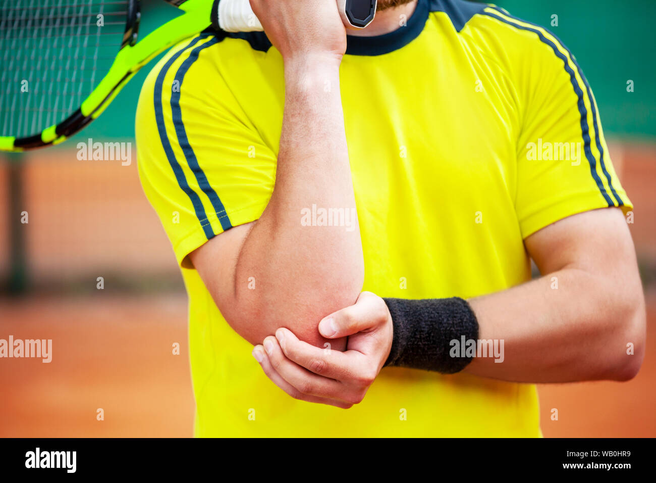 Tennista tenendo il suo gomito ferito. Il gomito del tennista concetto. Foto Stock