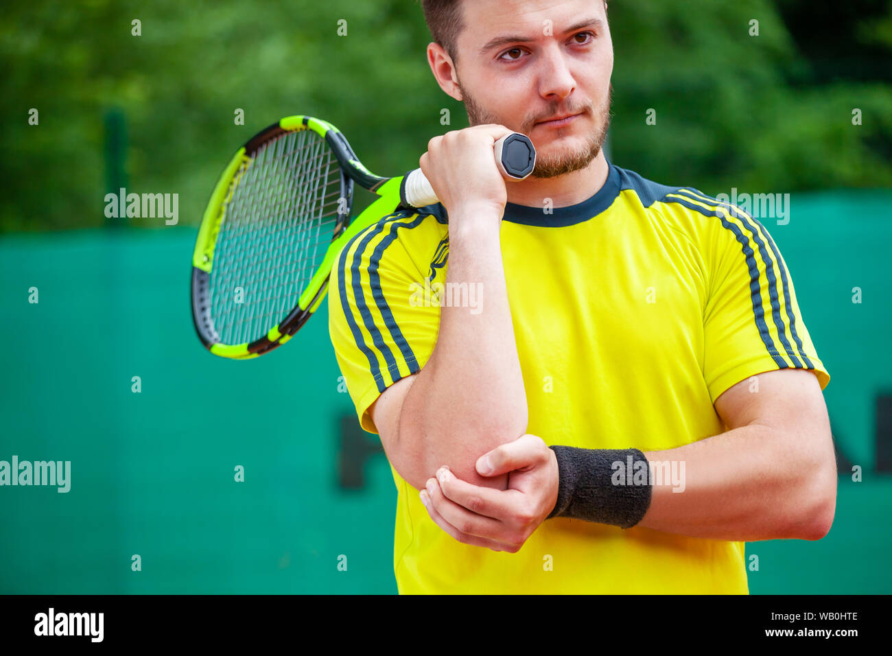 Tennista tenendo il suo gomito ferito. Il gomito del tennista concetto. Foto Stock
