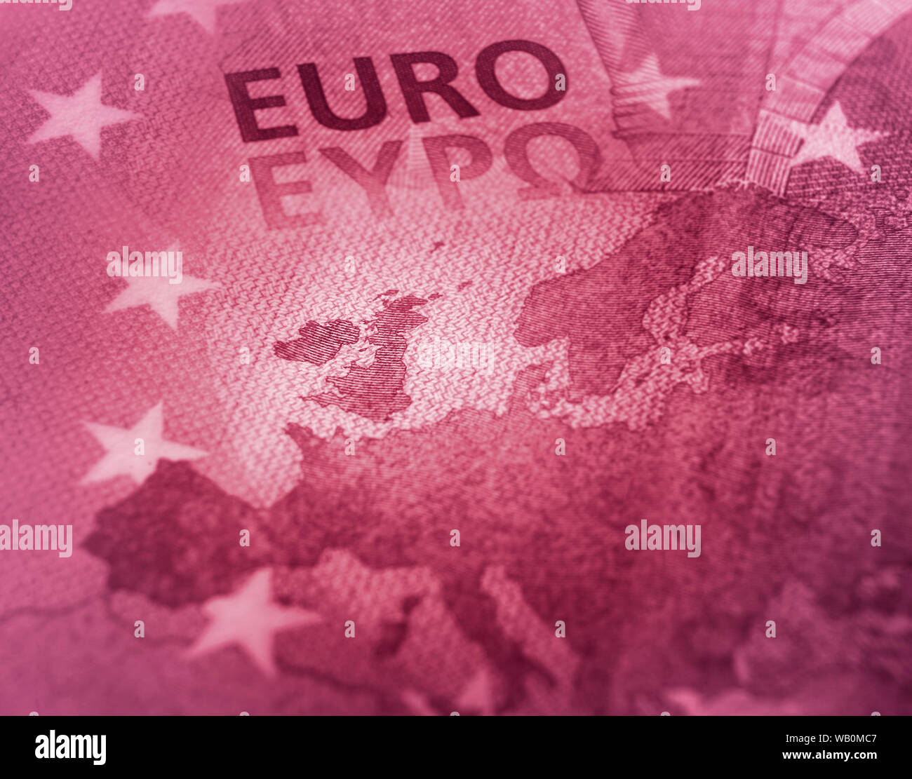 Disegno astratto. Unfocused Euro bill close up dettaglio della mappa dell'Europa con il focus sulla Gran Bretagna. Il colore rosso di tono. Foto Stock