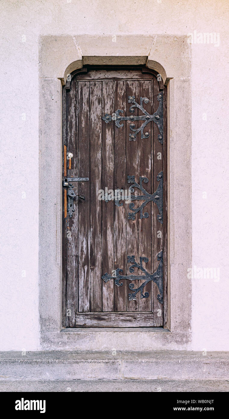 Chiusa antica porta in legno con cardini di ferro battuto Foto Stock