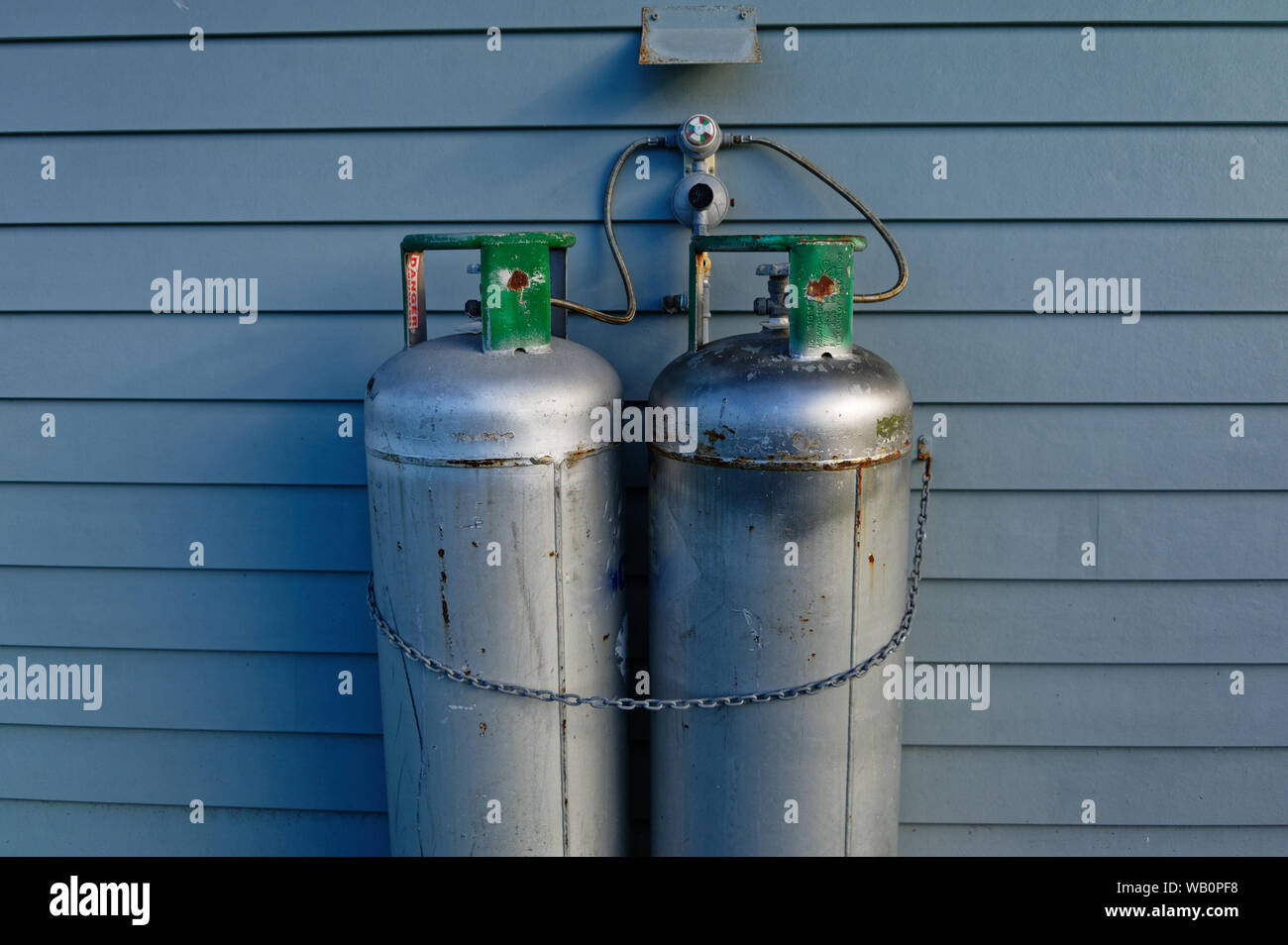 I serbatoi di gas siano saldamente incatenata al lato di una casa Foto Stock