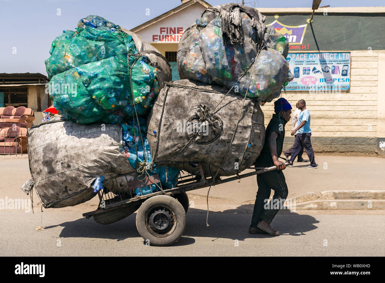 Carrello a mano estrattore trasportare grandi sacchi riempiti con materiale plastico di riciclo, Nairobi, Kenia Foto Stock