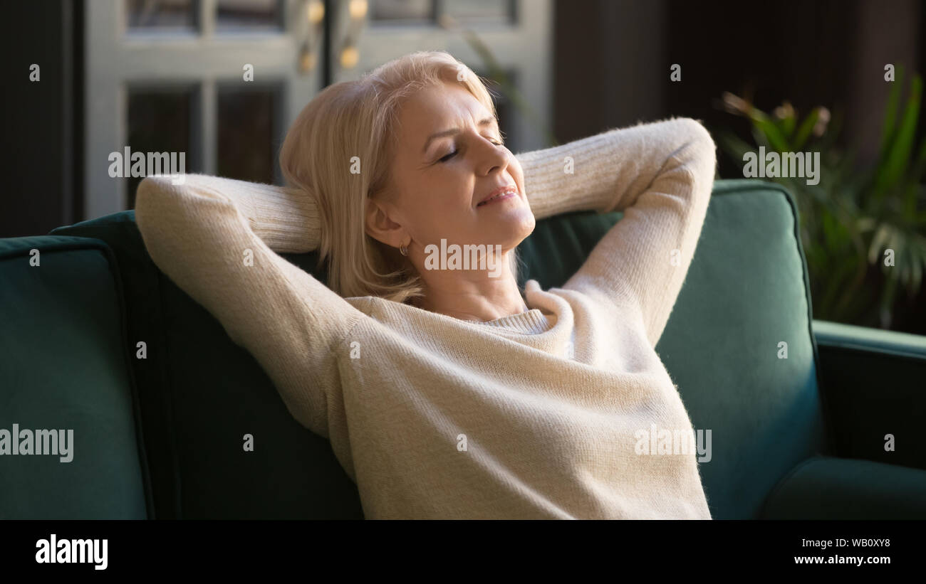 Calma felice vecchia donna rilassante con gli occhi chiusi sul lettino Foto Stock