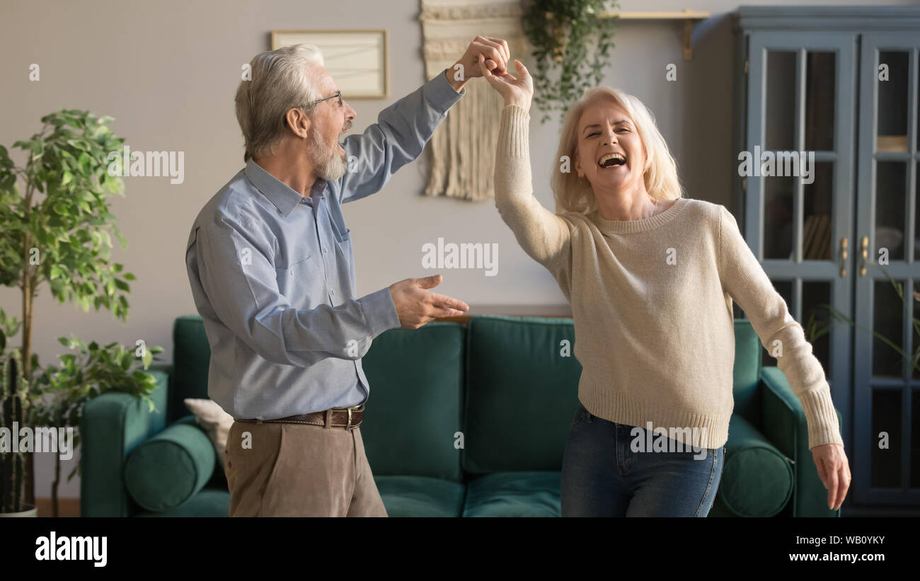 Gioiosa circa i vecchi pensionati coppia romantica in ballo nel soggiorno Foto Stock