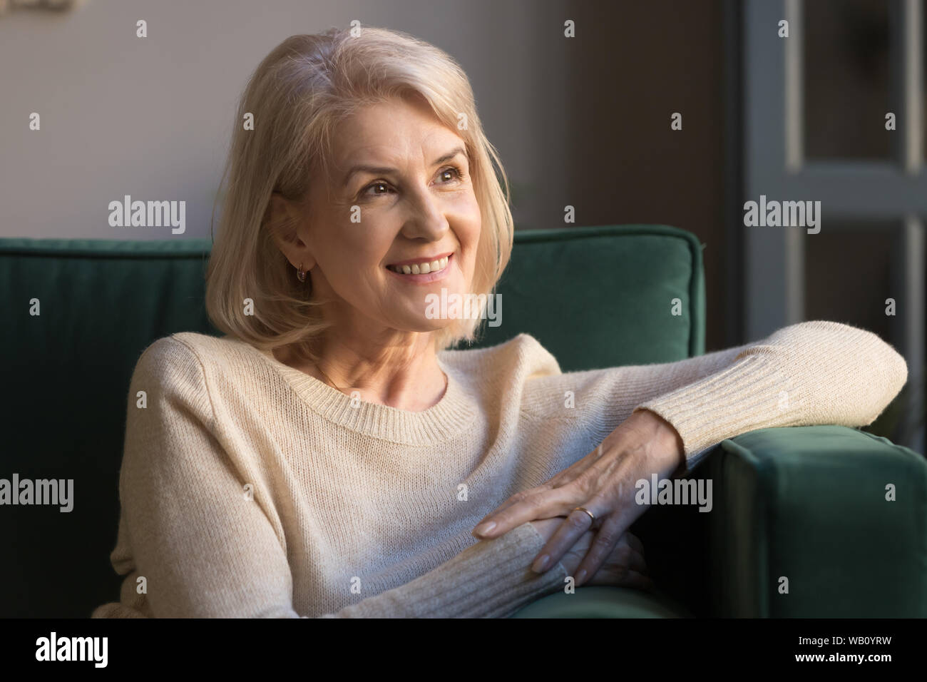 Sorridente sognante donna di mezza età il pensiero di un futuro felice Foto Stock