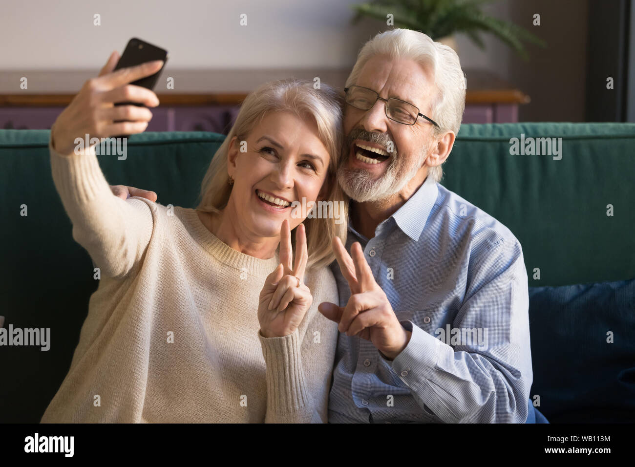 Felice divertente coppia coppia senior tenendo selfie guardando smartphone Foto Stock