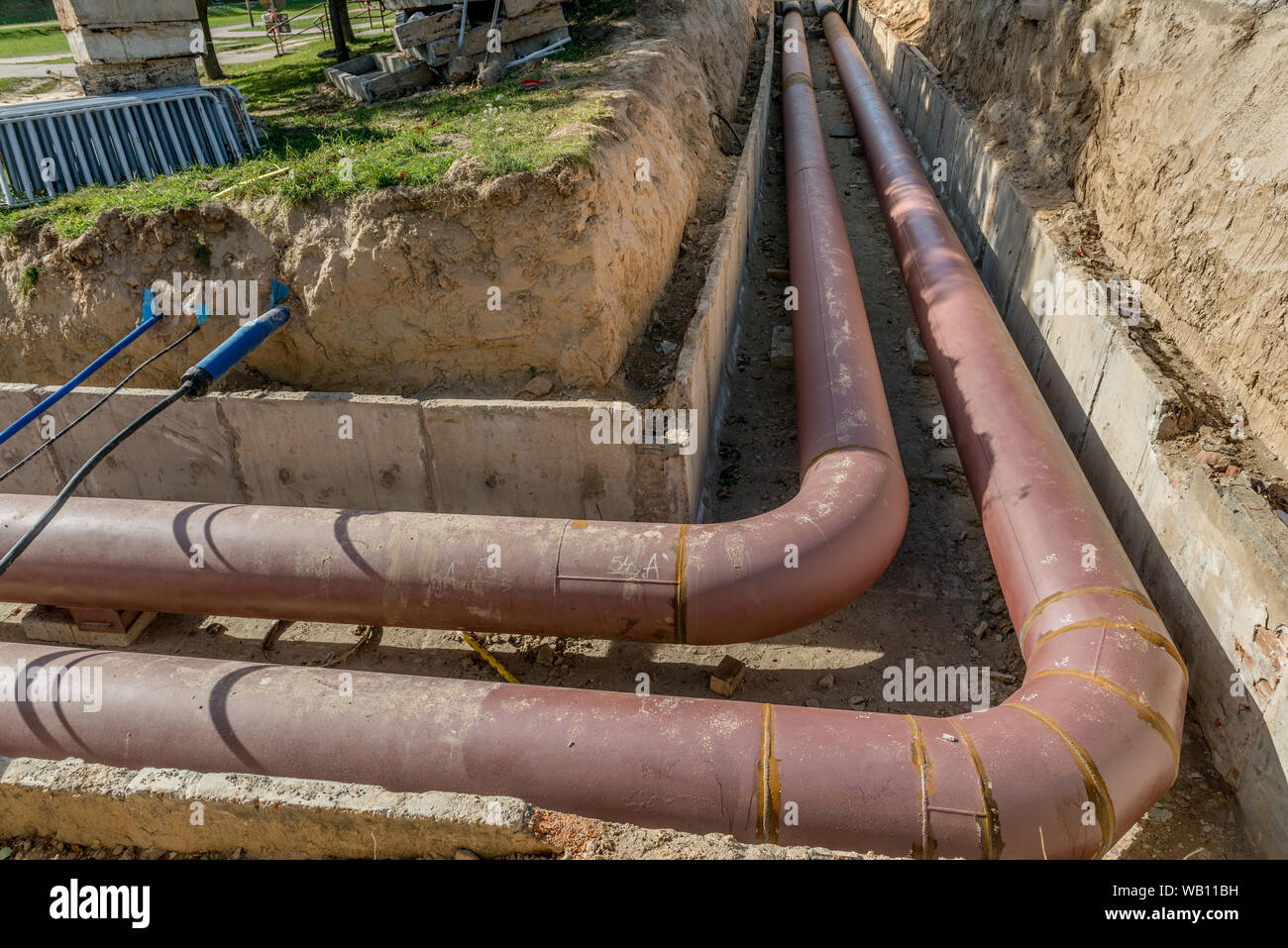 Tubazione interrata di installazione. Acciaio, gigante. Posa o sostituzione di tubazioni interrate. Installazione di tubazioni interrate. Infrastrutture di utilità Foto Stock