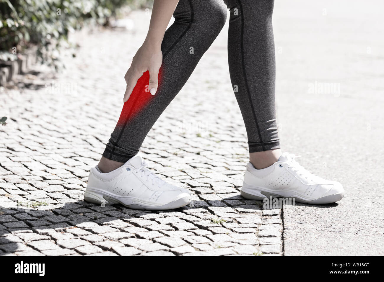 Close-up di una femmina di Runner che soffrono di dolore nel muscolo del polpaccio Foto Stock