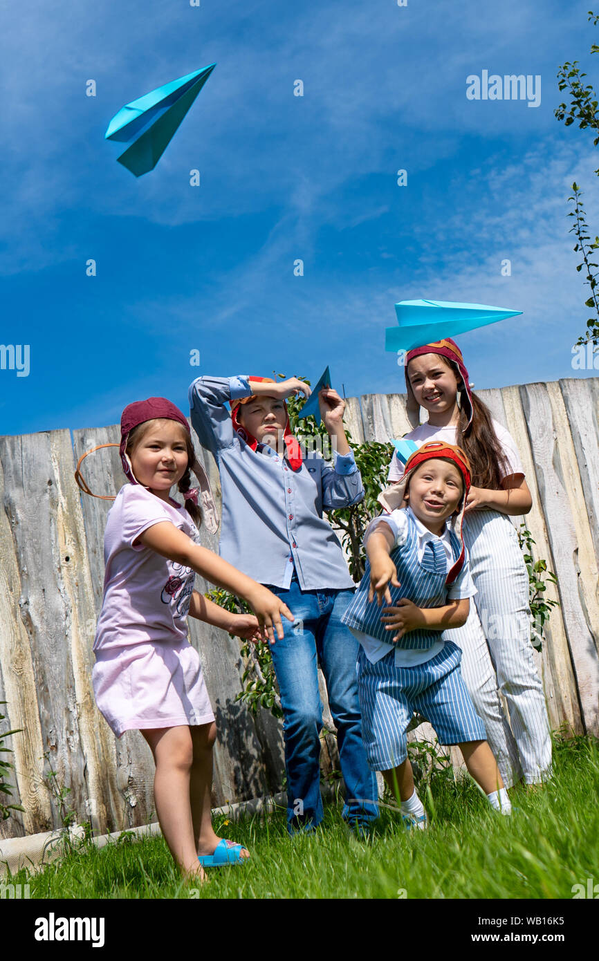 La regione di Celjabinsk, Russia - Agosto 2019.I bambini di differenti età giocare gli aeroplani di carta insieme. Ragazzi e una ragazza di decollo in cielo con il piano della carta Foto Stock