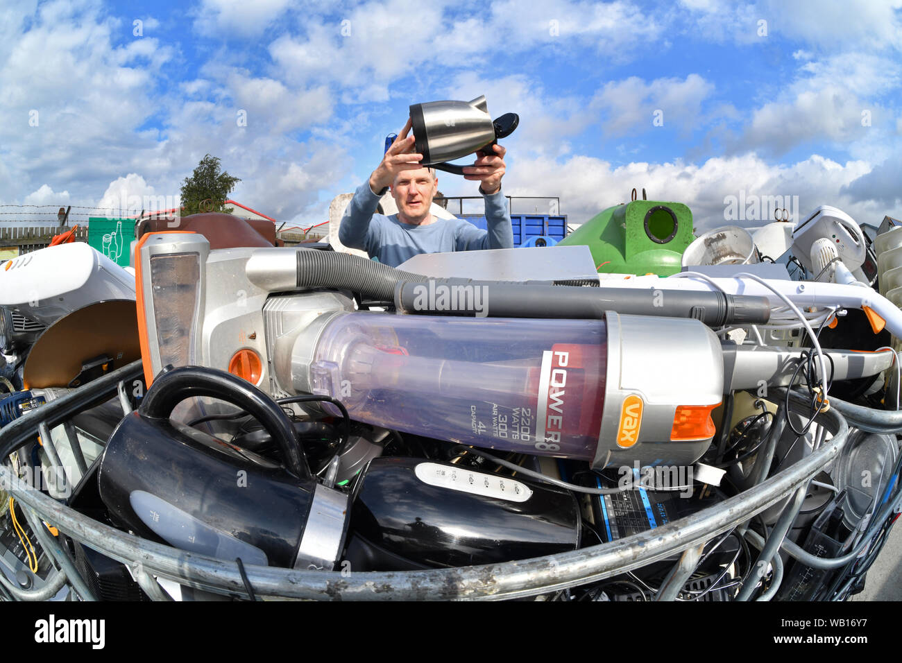 L'uomo lasciando apparecchio elettrico (RAEE) di riciclo al consiglio di riciclaggio domestico Centre Regno Unito Foto Stock