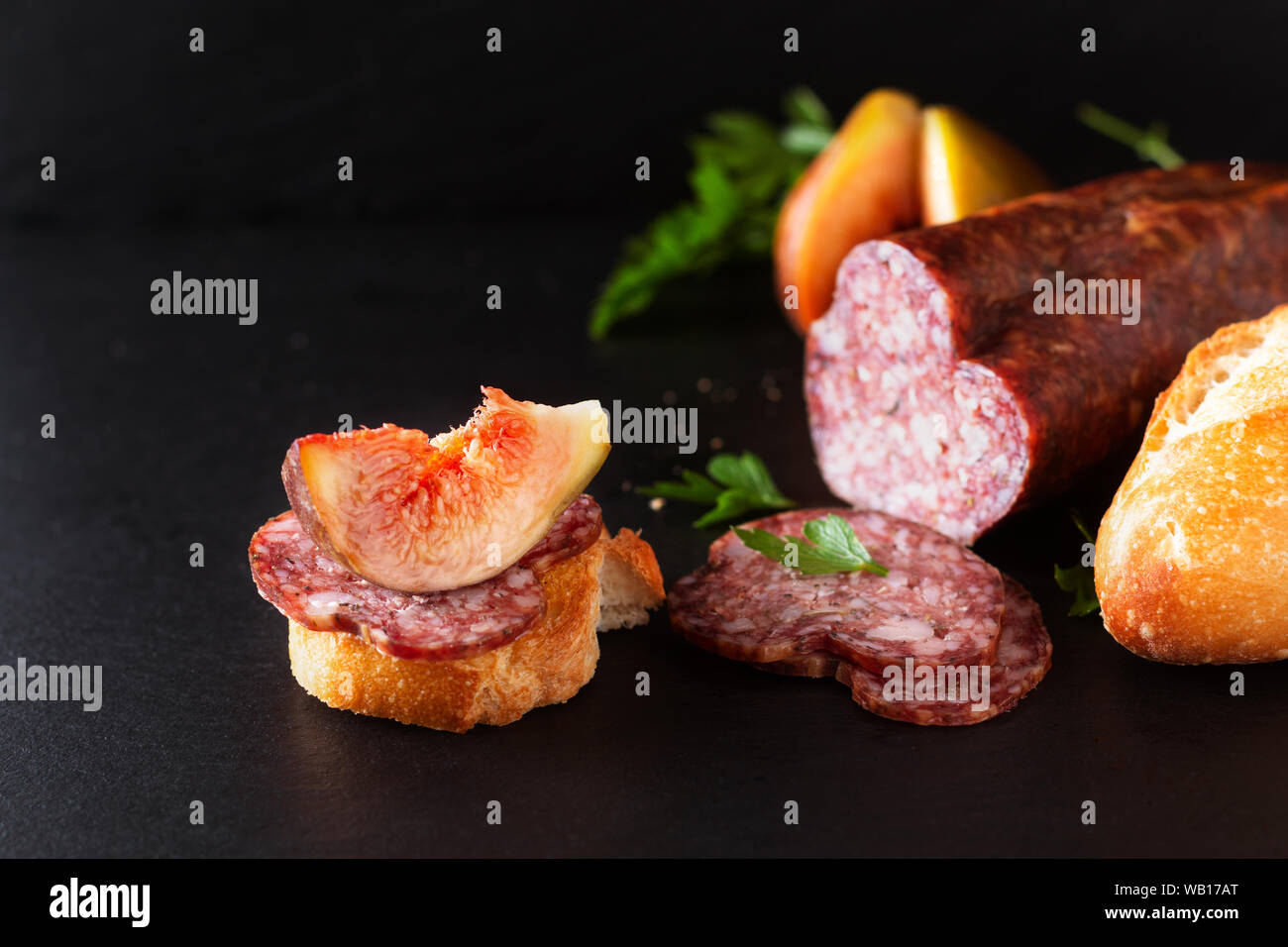 Concetto di alimenti secchi salsiccia indurito sul nero ardesia scheda con spazio di copia Foto Stock