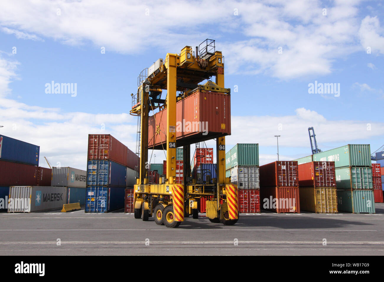 La guida "Straddle Carrier (Van Carrier) con un container nel porto di Auckland in Nuova Zelanda Foto Stock
