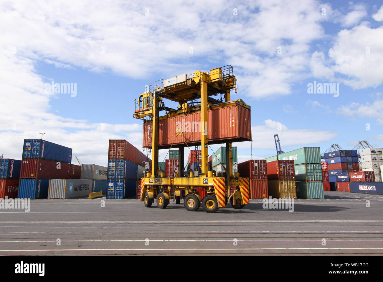 La guida "Straddle Carrier (Van Carrier) con un container nel porto di Auckland in Nuova Zelanda Foto Stock