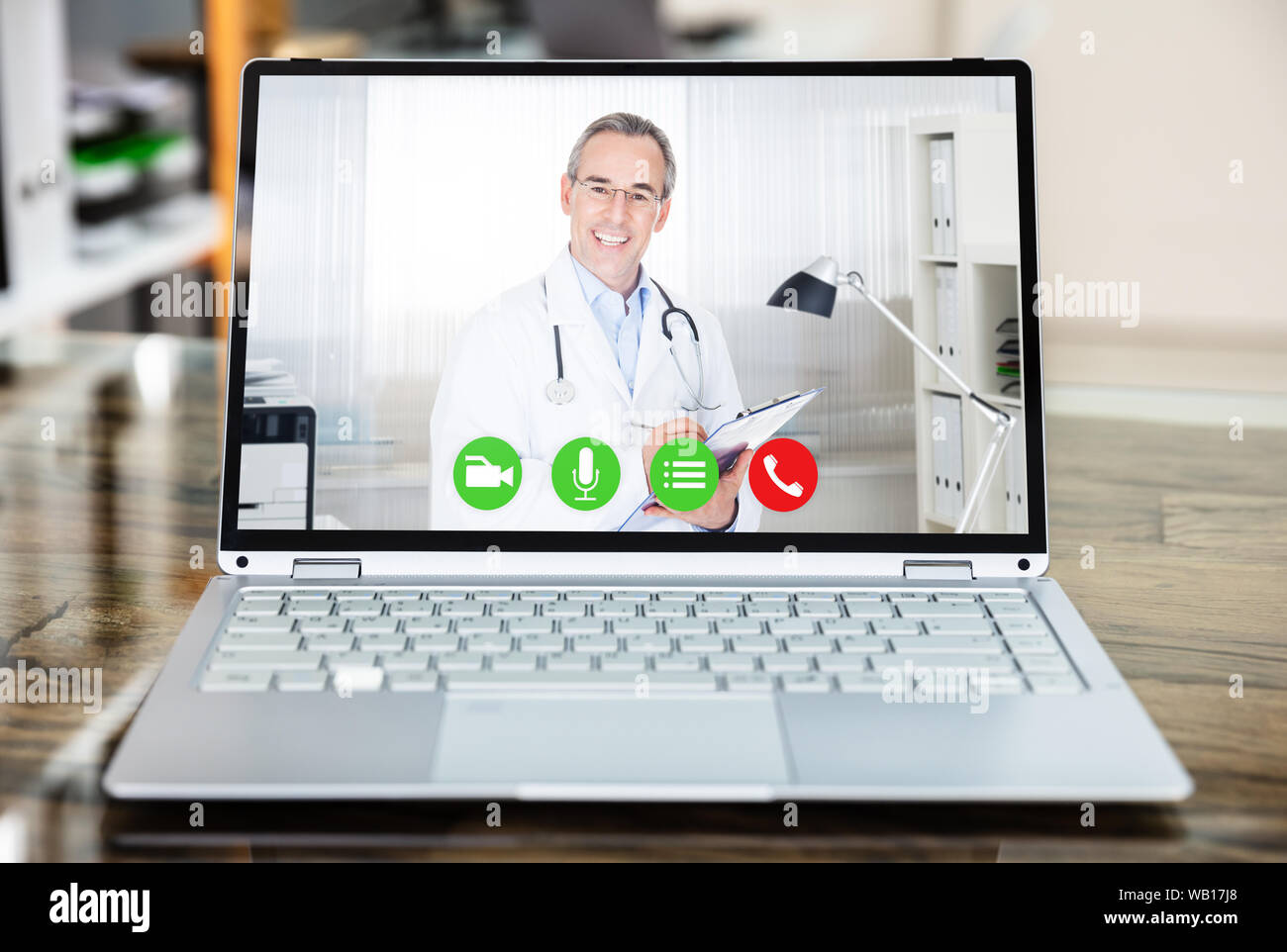 Medico sorridere mentre le videoconferenze su laptop in ospedale Foto Stock