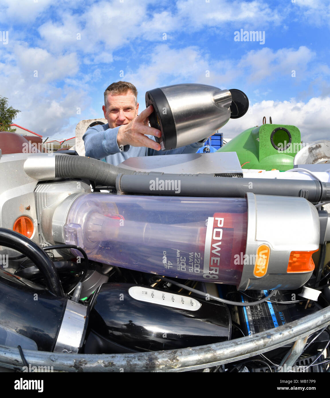 L'uomo lasciando apparecchio elettrico rotto bollitore (RAEE) di riciclo al consiglio di riciclaggio domestico Centre Regno Unito Foto Stock