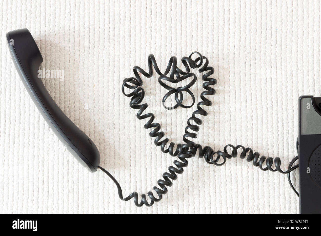 Nero a forma di cuore cavo telefonico su sfondo bianco Foto Stock