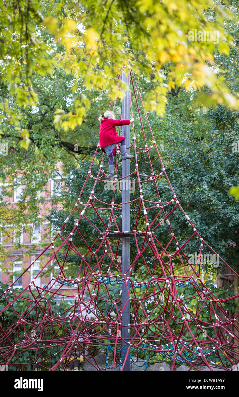 Bambina arrampicata sulla palestra nella giungla in autunno Foto Stock