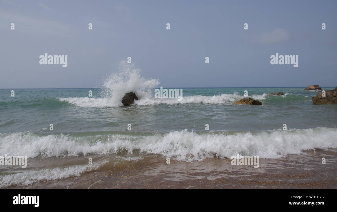 Spazzate dal vento Surf pesante, le onde infrangersi sulla costa Foto Stock