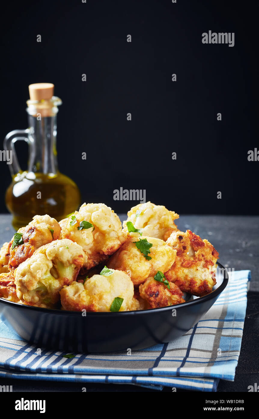 Tempura marocchino-style fritti cavolfiore servito in una ciotola su una tavola di cemento, vista verticale, close-up Foto Stock