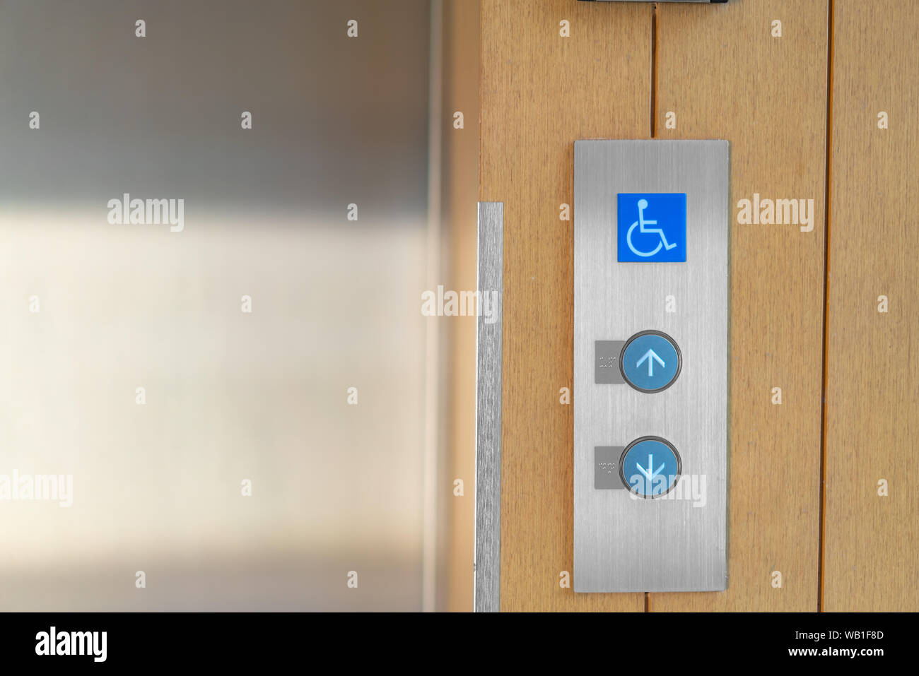 Ascensore pulsanti con i codici Braille e segno di handicap. Consentire indicazioni per verso l'alto e verso il basso. Foto Stock