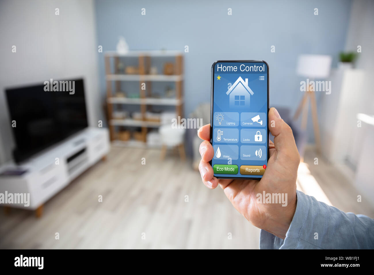 Uomo che utilizza Smart Home Applicazione sul telefono cellulare Foto Stock