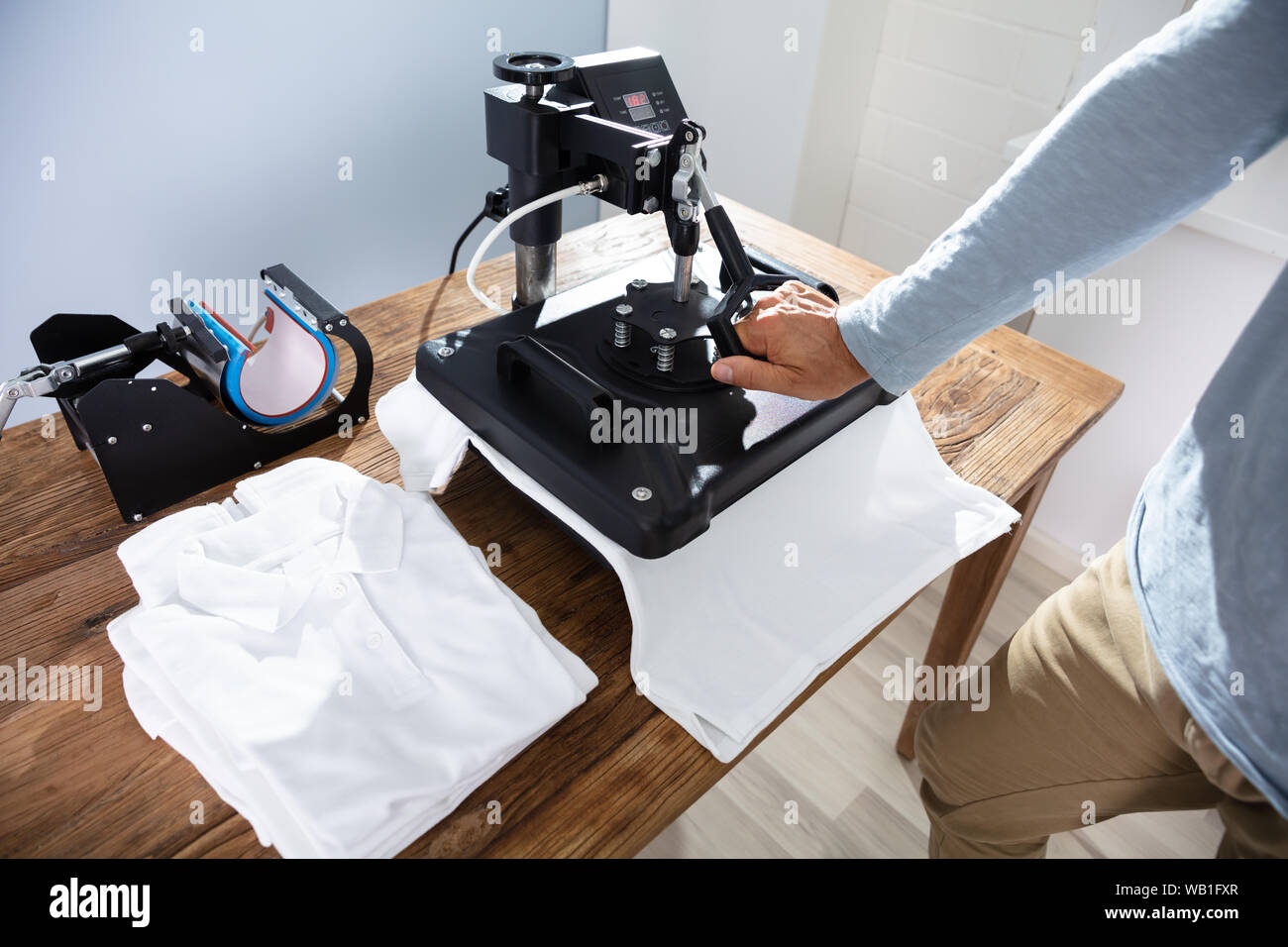 L'uomo immagine di stampa su T-Shirt in officina Foto Stock