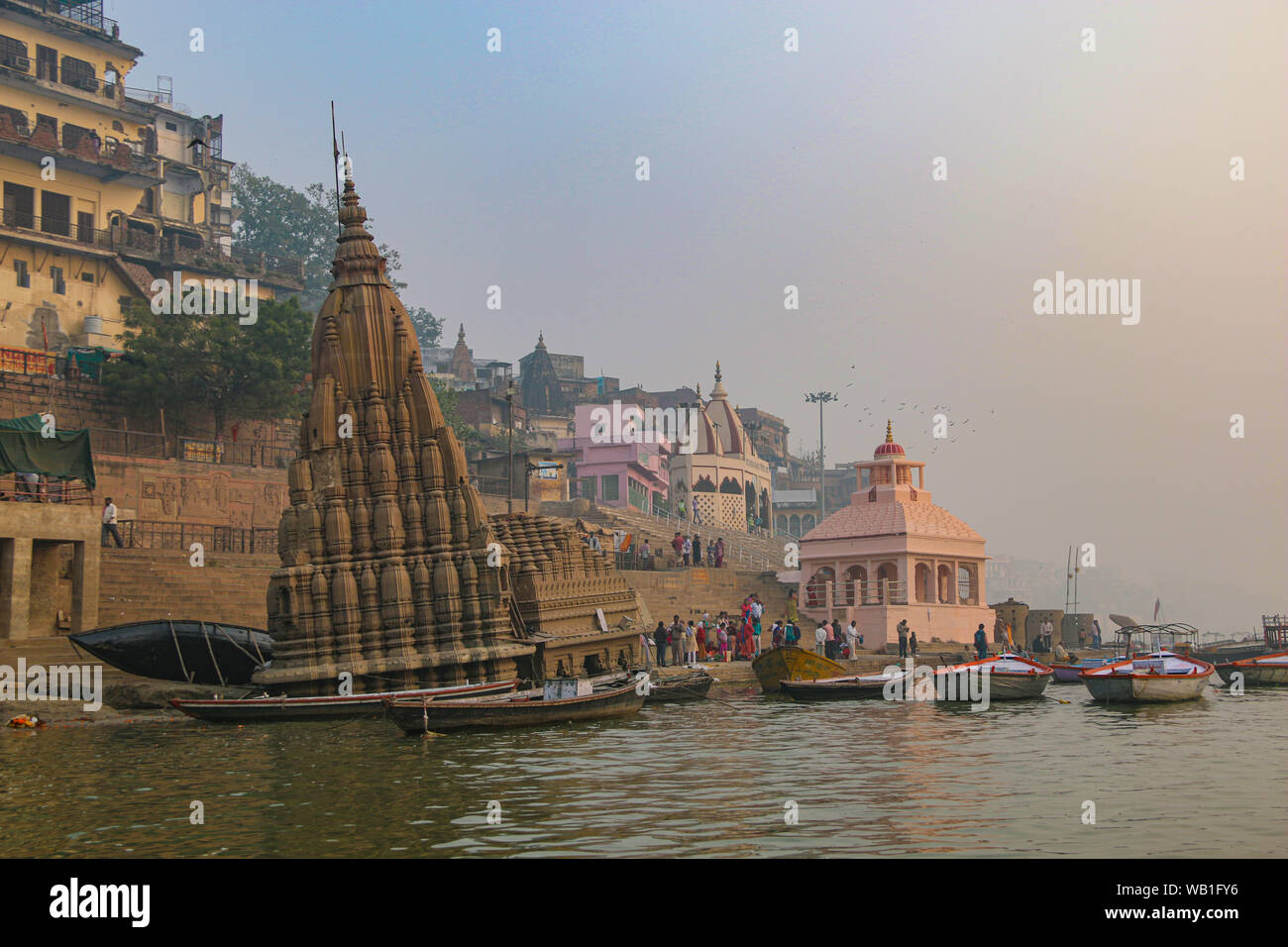 Foschia mattutina sul Fiume Gange, con il wonky riverbank tempio, Varanasi, India, Asia centrale Foto Stock