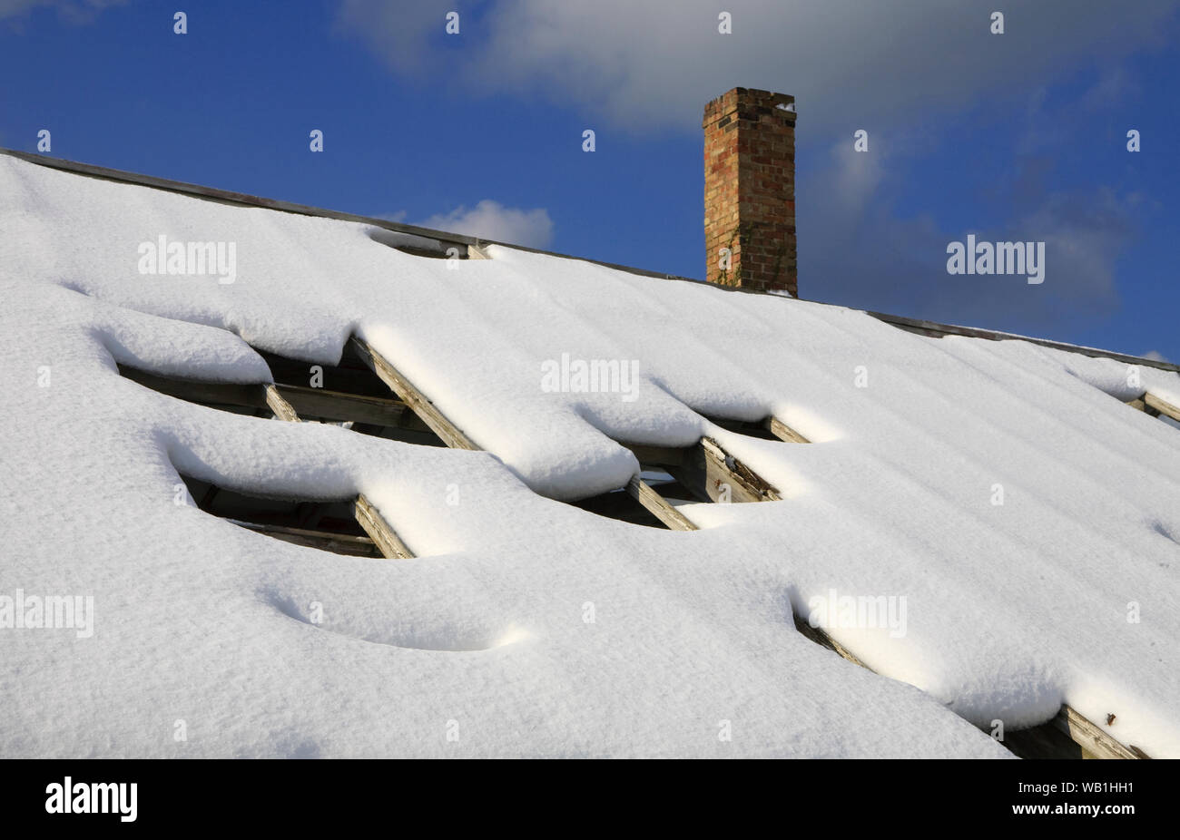 Un ex zone industriali glasshouse ricoperta di neve al sole con la neve inizia a sciogliersi. Foto Stock