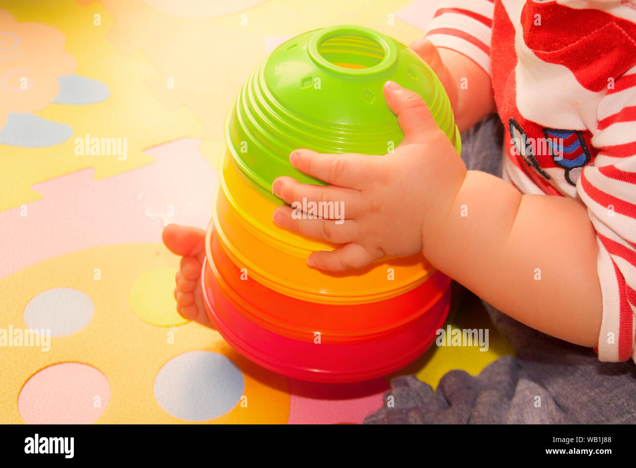 Close-up sul bambino che gioca con la coloratissima piramide giocattolo Foto Stock