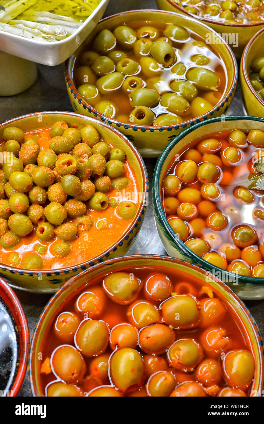 Olive marinate con erbe in un mercato. Foto Stock