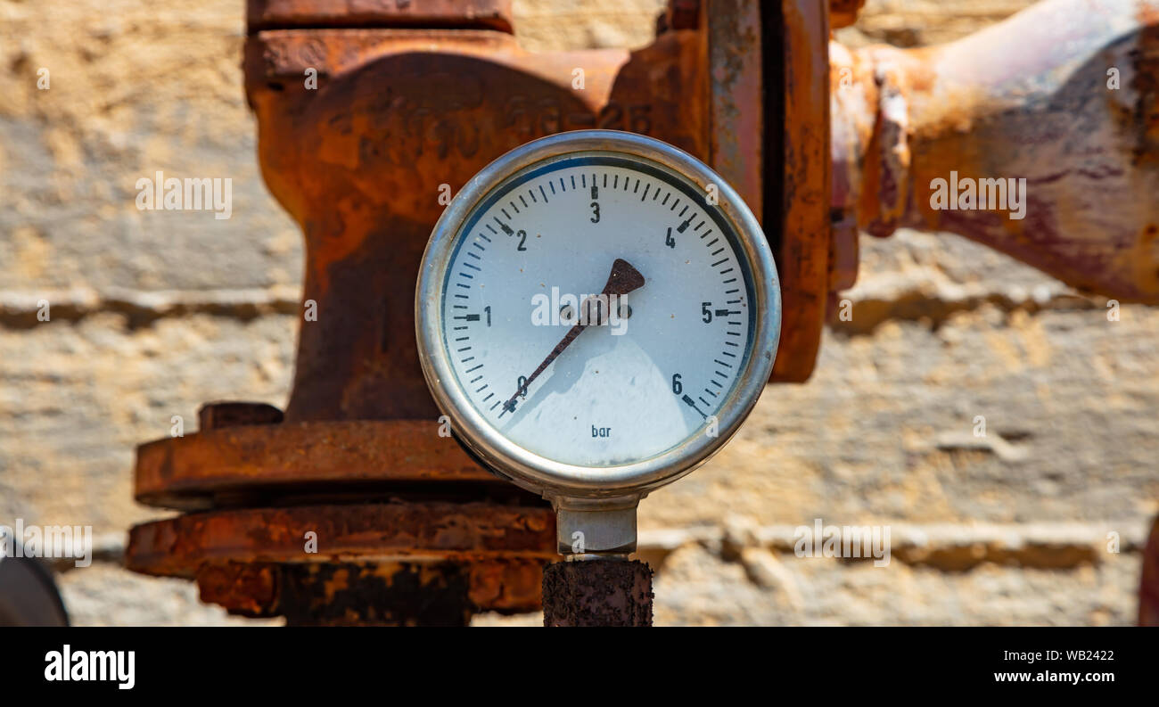 Alta pressione dei manometri, tubazioni e valvole, sfocatura dello sfondo industriale Foto Stock