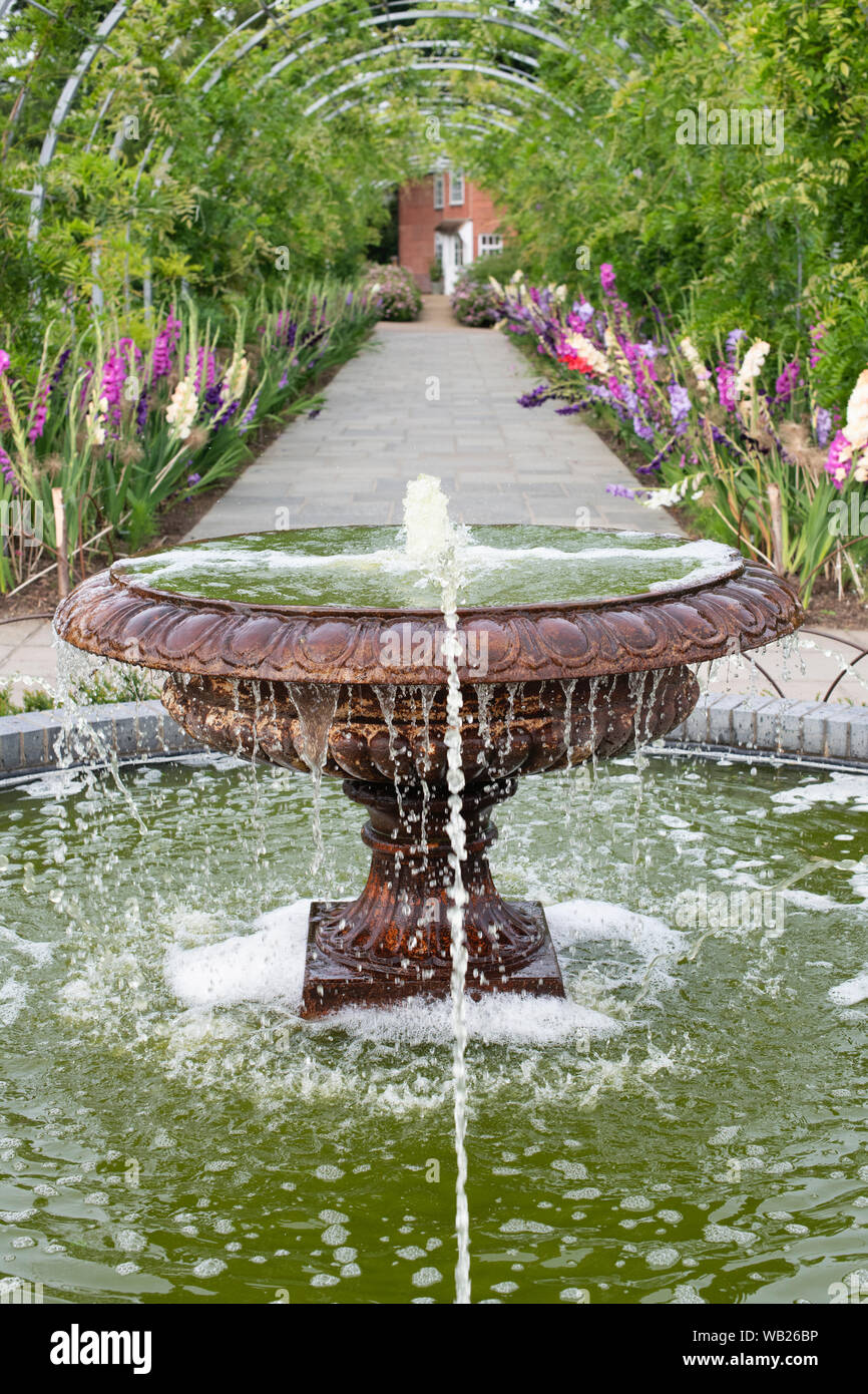 Funzione acqua e wisteria archway ad RHS Wisley Gardens, Surrey, Regno Unito Foto Stock