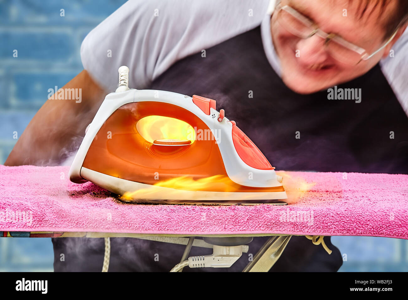 L'uomo ha dimenticato di spegnere il ferro dal punto di alimentazione e trovato che un incendio appiccato in casa perché il ferro era surriscaldato e incendiarsi, e t Foto Stock