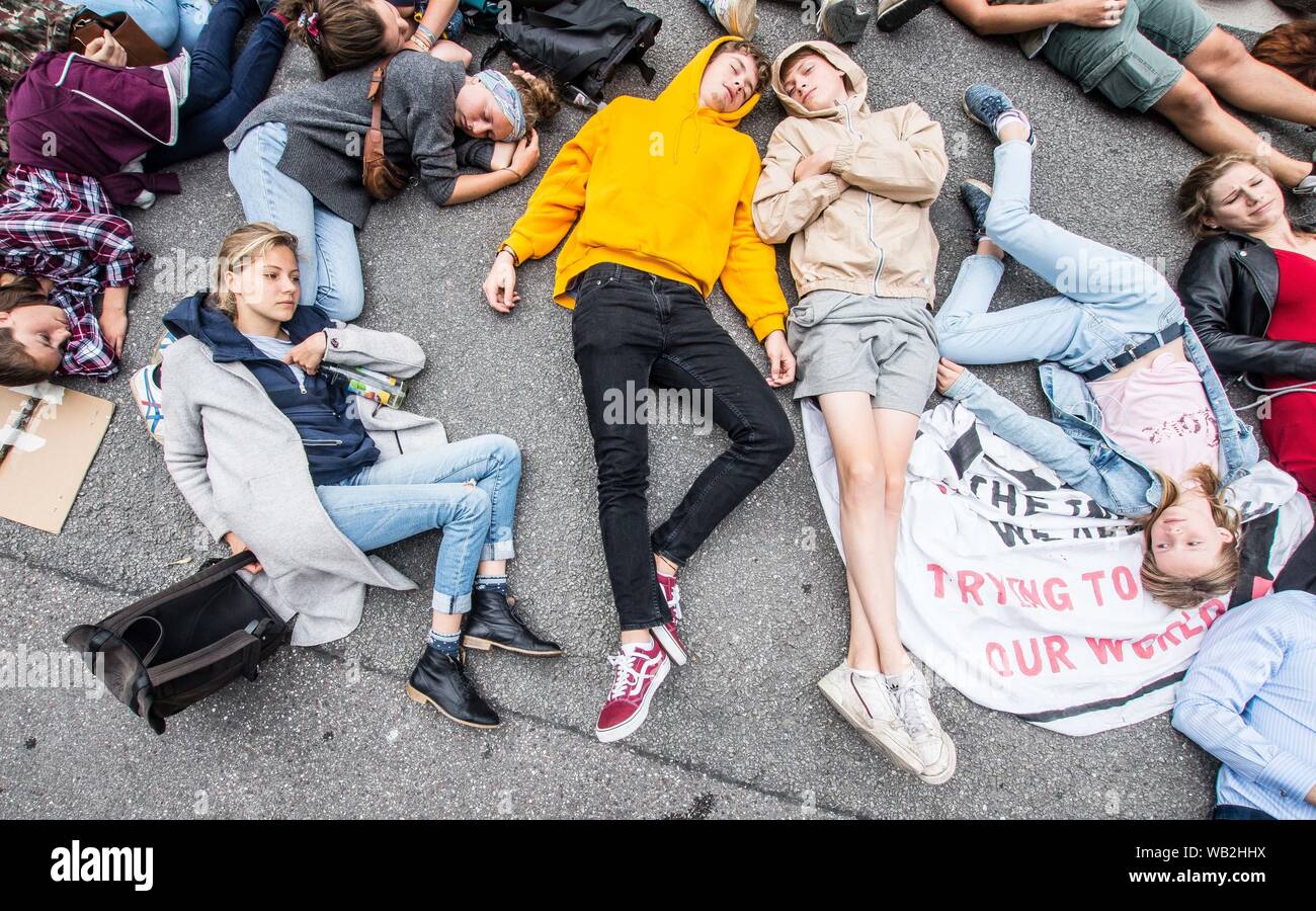 Monaco di Baviera, Germania. 23 Ago, 2019. Alcune delle centinaia di attivisti da venerdì per il futuro e la ribellione di estinzione in uno stampo in davanti al Consolato Brasiliano a Monaco di Baviera, Germania. Rispondendo a rivendicazioni da parte di al Presidente del Brasile Bolsonaro che le ONG possono avere impostato gli incendi che attualmente infuria attraverso l'Amazzonia, attivisti dalla ribellione di estinzione e quindi il venerdì per il futuro si sono riuniti di fronte all'ambasciata brasiliana a Monaco di Baviera, Germania utilizzando una filiera in centinaia di grandi per portare attenzione alla distruzione della più grande del mondo di anidride carbonica repository attualmente in corso. (Credito Ima Foto Stock