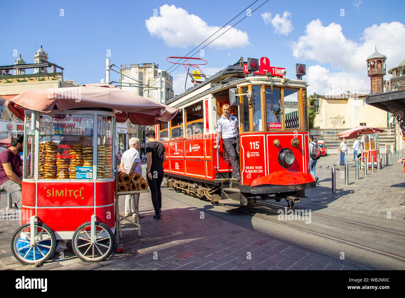 Istanbul, Turchia - 05 agosto 2019: il tram nostalgico accanto a un carrello la vendita tradizionale turca simit al Taksim fine del famoso Istiklal Caddes Foto Stock