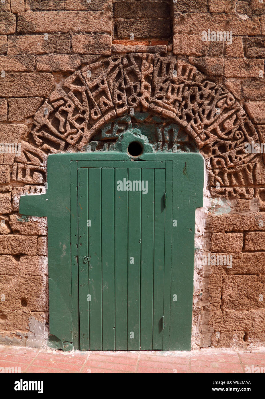 Il Marocco, El Jadida, bella antica moschea. Dettaglio della porta e la calligrafia Araba scolpiti nella facciata in pietra. UNESCO - Sito Patrimonio dell'umanità. Foto Stock