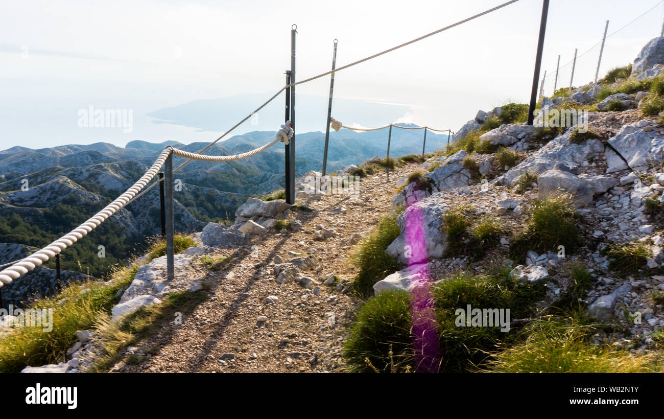 Sassoso sentiero con fune recinzione in montagna Biokovo, Riviera di Makarska, Croazia Foto Stock