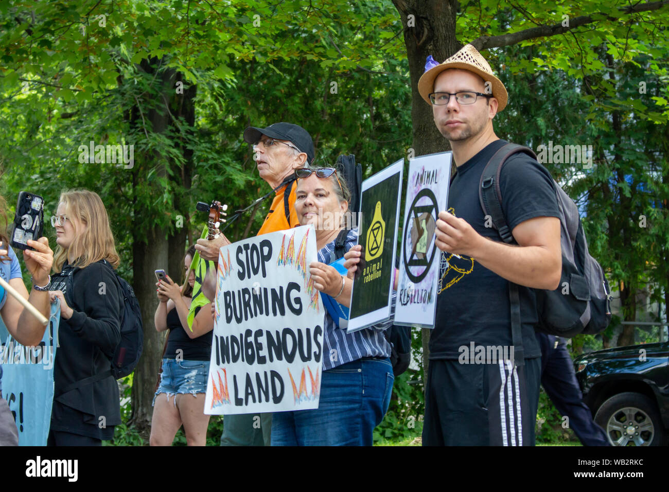 OTTAWA, Ontario, Canada - 23 agosto 2019: gli attivisti al di fuori dell'Ambasciata del Brasile tenere indicazioni per protestare la masterizzazione attuale della foresta pluviale amazzonica. Foto Stock