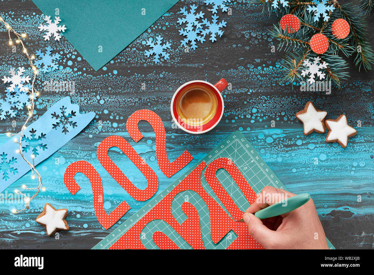 Concetto di sfondo inverno, carta artigianale con taglio a mano numero 2020, una tazza di caffè e le decorazioni di Natale. Appartamento laico, vista dall'alto sul Menta astratta col Foto Stock