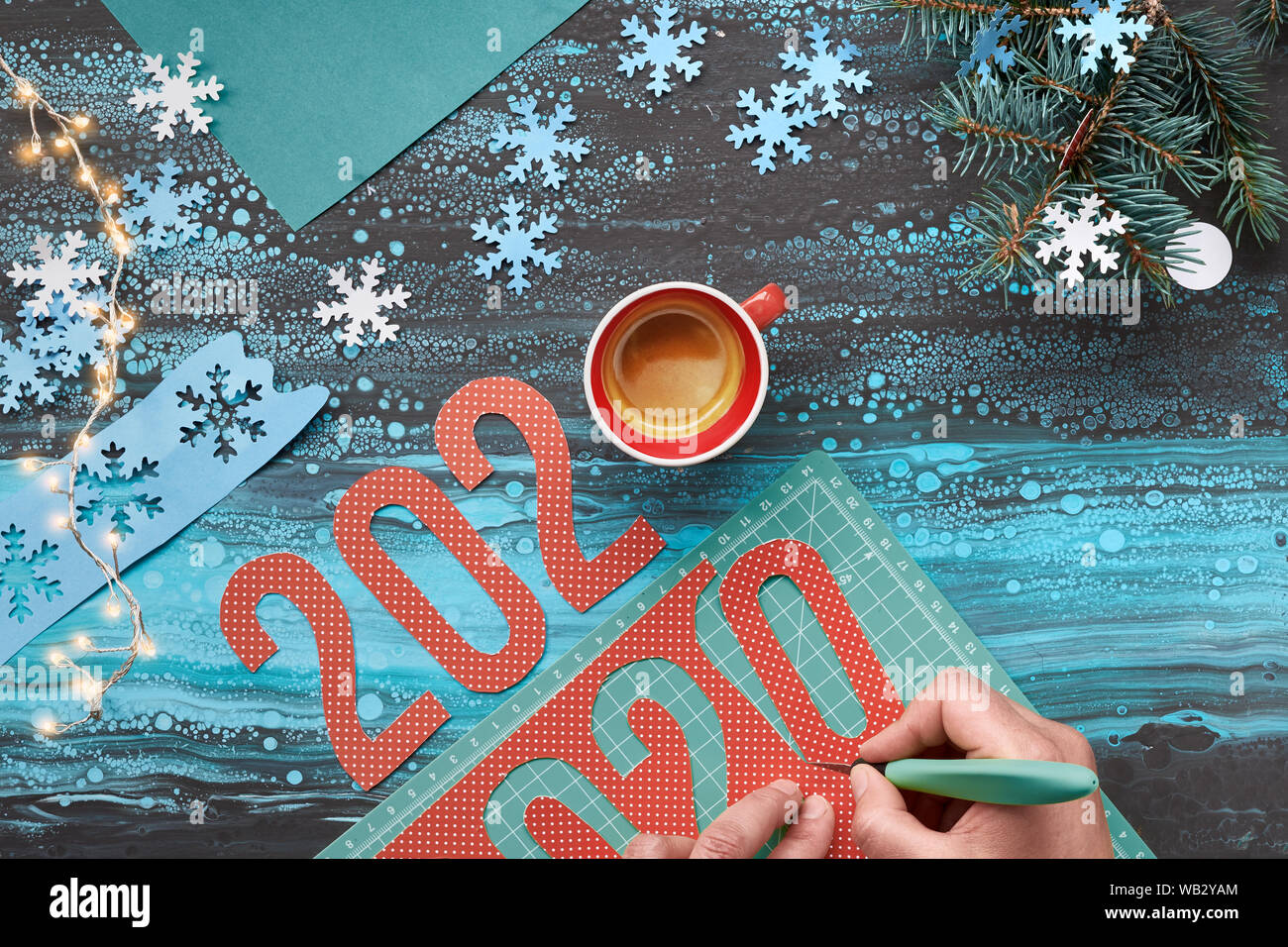 Concetto di sfondo inverno, carta artigianale con taglio a mano numero 2020, una tazza di caffè e le decorazioni di Natale. Appartamento laico, vista dall'alto sul Menta astratta col Foto Stock