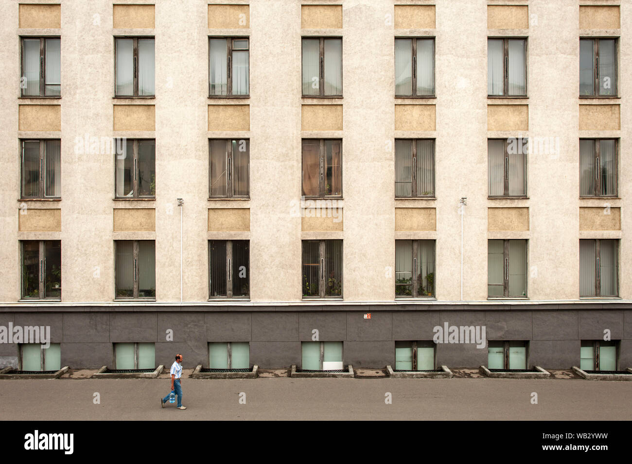 L'uomo walkng davanti a un edificio a Minsk, in Bielorussia. Foto Stock