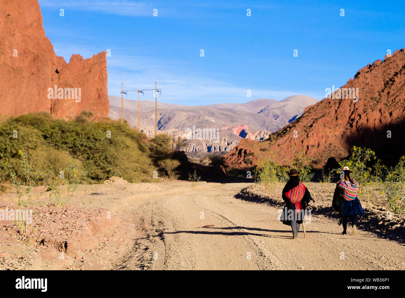 Popolo boliviano a piedi lungo la strada sterrata in Bolivia. Paesaggio boliviano Foto Stock
